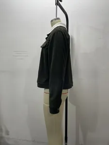 Detailed view of the dark green corduroy jacket with white fleece collar texture