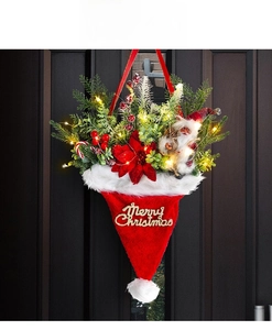 Luminous Christmas hat wreath with LED lights pine needles and Merry Christmas sign on wood door