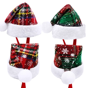 Detailed view of red and green plaid pet Christmas hats with white snowflake patterns