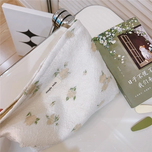 Detailed macro view of cream floral waffle fabric bag with simple wish woven label
