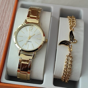 Dettaglio di orologio al quarzo dorato e bracciale con farfalla in scatola regalo