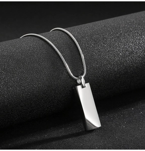 Close-up of a polished silver titanium steel rectangular pendant on a sleek snake chain