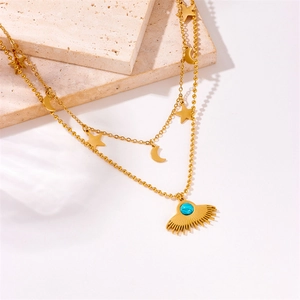 Detail of layered gold necklace with turquoise sunburst pendant and celestial charms