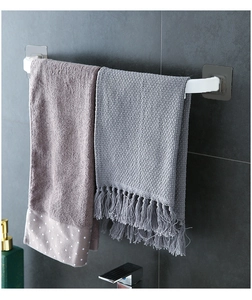 White bathroom towel rack on dark gray tile showing adhesive mounting detail