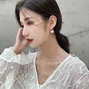 Minimalist double circle earrings with pink cat eye stones worn by a female model