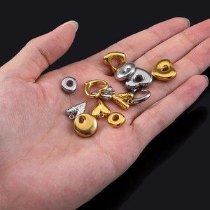 Golden and silver 3D heart charms and metal beads held in palm for DIY jewelry