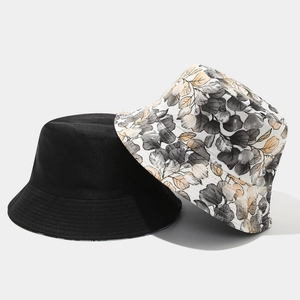 Detail of reversible bucket hats in plain black and floral leaf print cotton canvas