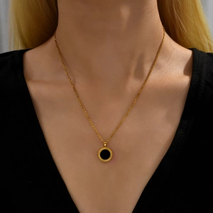 Chic gold chain necklace with black circular shell inlay pendant shown on a model