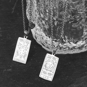 Macro detail of Capricorn and Leo tarot style stainless steel necklace pendants