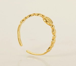Détail de la bague ajustable dorée avec un design de pièce de monnaie en relief