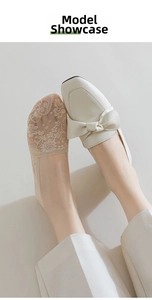 Close-up of beige lace no-show socks with floral texture and white bow loafers