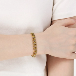 Detail view of gold layered bracelet with twisted rope chain and zircon stones