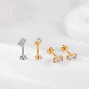 Gros plan de piercings labret F136 en titane avec zircon rectangulaire doré et argenté