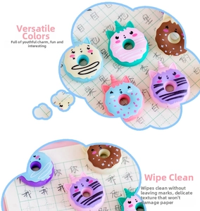 Close-up of cute unicorn and cat doughnut erasers in pastel colors on grid paper