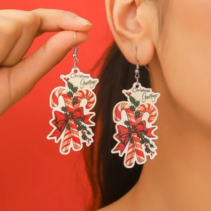 Detail of candy cane Christmas earrings with red bow and holly leaves decoration