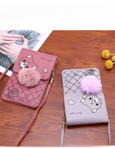 Detail of mini crossbody phone bags with cartoon fox print and plush ball charms