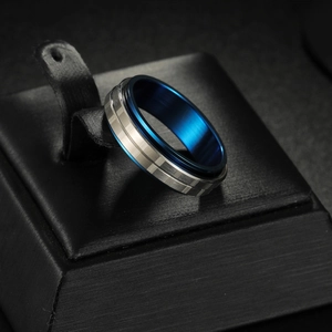 Detail view of rotating spinner ring with silver brushed finish and blue inner band