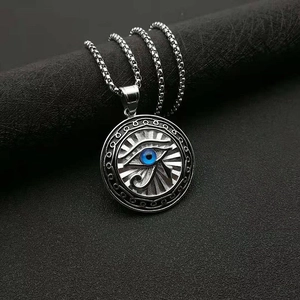 Close-up of Eye of Horus pendant with blue stone inlay on a dark textured background