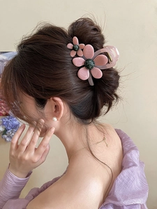 Detail einer Haarspange mit rosa Organza-Blume und Perle, getragen am Hinterkopf