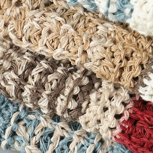 Macro detail of breathable hollow knit fabric in striped beige, blue and red patterns