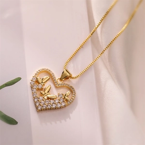 Macro detail of a golden heart pendant necklace featuring zircon pavé and 3D butterflies
