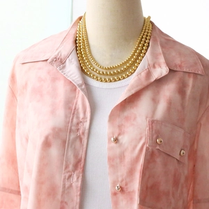Close-up of triple-layered 18k gold plated bead chain necklace on a female model