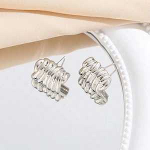 Boucles d'oreilles argentées chic avec texture plissée sur plateau en satin