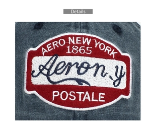 Dettaglio macro del ricamo AERO NEW YORK 1865 sulla berretto in denim lavato