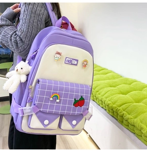 Close-up of light purple school backpack with fashion patches and cute bear pendant