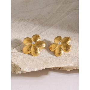 Close-up of 18k gold-plated flower stud earrings with matte texture and crystal center