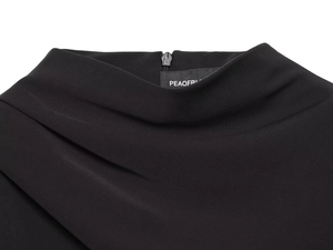 Detail view of the black mini dress featuring a pleated high neck and invisible back zipper