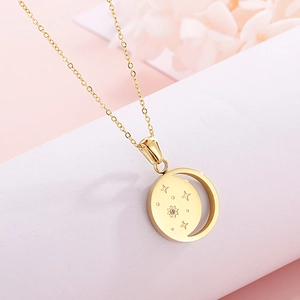 Macro shot of gold crescent moon necklace with star pattern and sparkling gem inlay