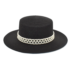 Close-up of black boater hat with woven faux pearl band showing intricate texture