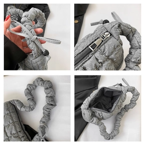 Detailed view of silver quilted crossbody bag with ruched handle and bow accents