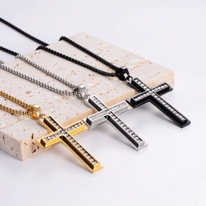 Detailed view of three-color rhinestone cross necklaces on a beige stone stand