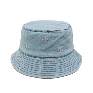 Detail of light blue denim bucket hat with pink bow embroidery and fine stitching