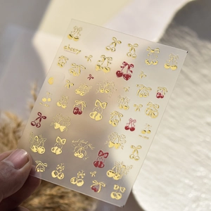 Close-up of Cherry Sweet nail art stickers with gold and red cherry patterns