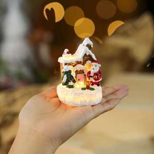 Handheld glowing Christmas resin cottage with Santa Claus and snowy tree decoration