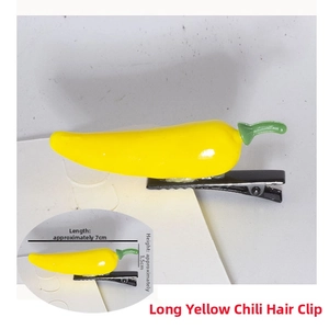 Detailed view of a 7cm yellow pepper hair clip with green stem on a metal duckbill clip