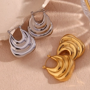Detail of chunky triple-layered wavy earrings in gold and silver stainless steel