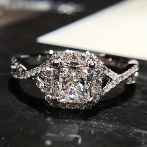 Détail macro de la bague de fiançailles taille coussin avec halo et anneau torsadé