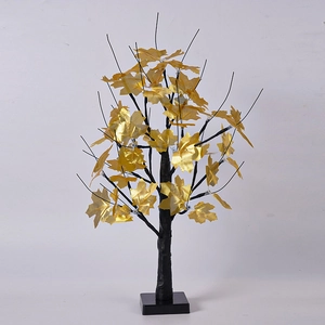 Detail of LED birch tree lamp with golden maple leaves and a sleek black trunk base