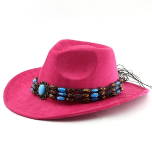Detail of fuchsia suede cowboy hat featuring ethnic beadwork and side tassel accents