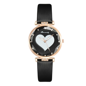 Detail of faceted glass watch face with heart pattern and rhinestone accents