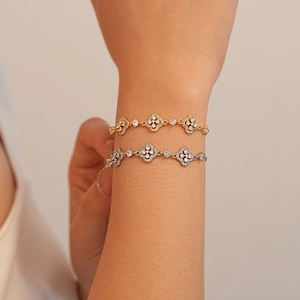 Bracelets trèfles élégants en or et argent avec zircons brillants portés par un mannequin