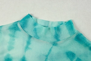 Close-up of mint green tie-dye mesh fabric showing the turtleneck neckline and texture