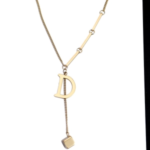 Golden Y-shaped titanium steel necklace featuring letter D pendant and minimalist cube charm