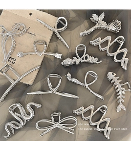 Flat lay of diverse silver metal hair claws including butterfly and floral shapes