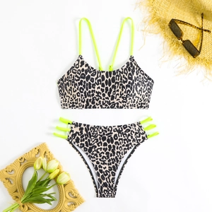 Flat lay of black and white leopard print bikini with neon yellow straps and summer decor