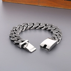 Detail of silver Cuban link bracelet with grid texture and secure clasp closure